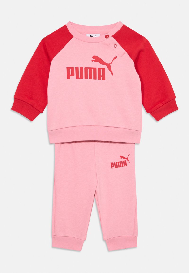 Rosa-rote Sweatshirt mit langen Ärmeln und einem Logo. Passende rosa Hose mit einem Logo. Weicher Stoff, Raglan-Design und Druckknopfdetails.