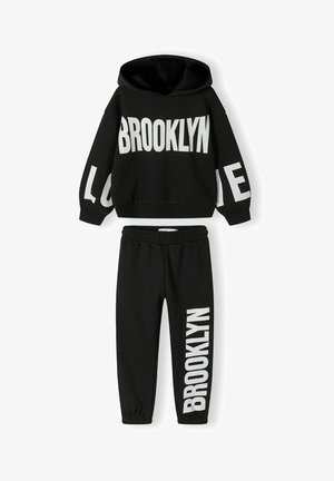Fekete sportos szett, amely egy kapucnis pulóvert és passzoló melegegítőt tartalmaz. A merész fehér feliratok: "BROOKLYN" és "LOVE" díszítik. Puha tapintás, laza fazon.