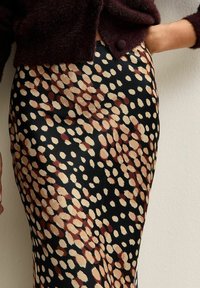 Bruine en beige gevlekte rok met een zwarte achtergrond, met een gladde stof en een getailleerd ontwerp dat tot halverwege de kuit reikt.