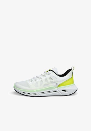 Chaussure de sport blanche avec tige en mesh, accents jaune-vert, et une semelle épaisse et rembourrée présentant des sections découpées pour la respirabilité.