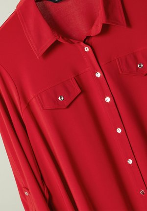Rotes Hemd mit Knopfleiste, glatter Textur, zwei Brusttaschen und silbernen Knopfakzenten; verfügt über einen klassischen Kragen und lange Ärmel.