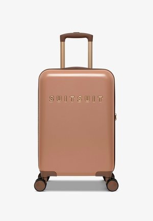 Hard-shell suitcase in rose gold with a smooth finish, featuring a gold logo, extendable handle, and four multi-directional wheels.