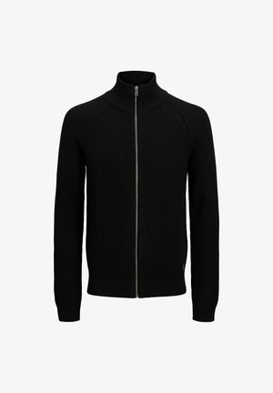 Melnā riboto adījumu piedurkņu džemperis ar augstu apkakli, garām piedurknēm un sudraba rāvējslēdzēju. Piemīt slaida piegriezne un teksturēta auduma struktūra.