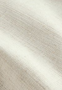 Beige textil szövet, finom szőtt textúrával. Finom tónusbeli eltérések az egész felületen, amelyek a természetes szálakat tükrözik, lágy és visszafogott megjelenést kölcsönözve.