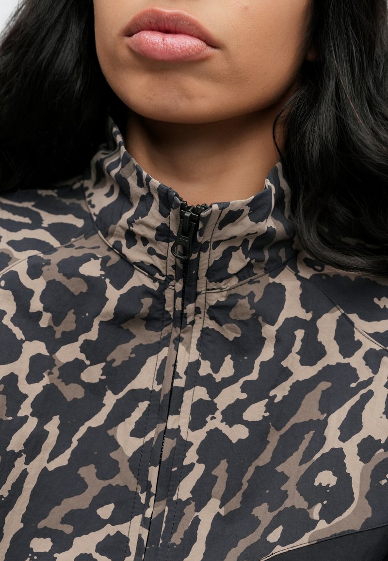 Jas met ritssluiting in een beige en donkerblauwe dierenprint. Heeft een hoge kraag en een gladde stof met een casual ontwerp.