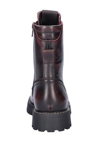 Bottines en cuir marron avec une texture lisse, un dos renforcé et une semelle extérieure en caoutchouc noir robuste. Elles présentent une fermeture éclair verticale et des coutures contrastantes.