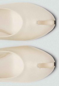 Scarpe in pelle beige con punta arrotondata e un taglio orizzontale nell'avampiede; texture liscia e dettagli di cucitura minimi.
