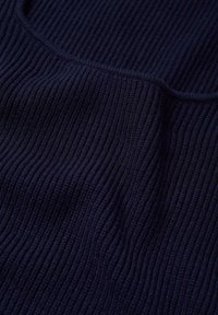 Tissu en tricot côtelé bleu marine foncé présentant de fines stries verticales avec une couture traversant horizontalement la section médiane.