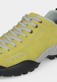 Κίτρινο δερμάτινο ορειβατικό παπούτσι με γκρι κορδόνια, μαύρη σόλα με πέλμα και κεντημένο λογότυπο "SCARPA" στο πλάι.