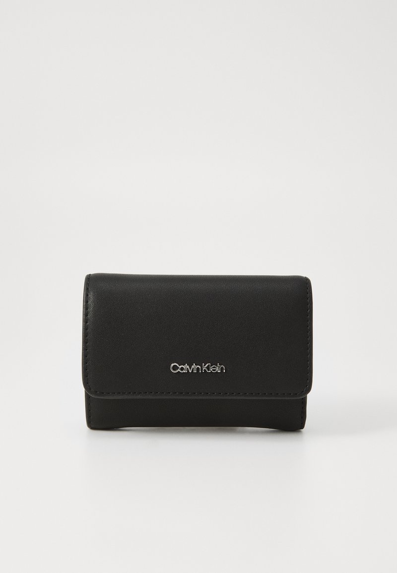 Černá kožená peněženka s designem na přehyb, zdobená stříbrným logem Calvin Klein a čistými švy. Kompaktní tvar s hladkým povrchem.