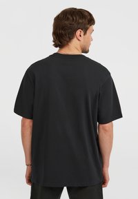 Svart bomull t-skjorte med avslappet passform, korte ermer og rund hals. Glatt tekstur og minimalistisk design, ingen synlige logoer eller mønstre.