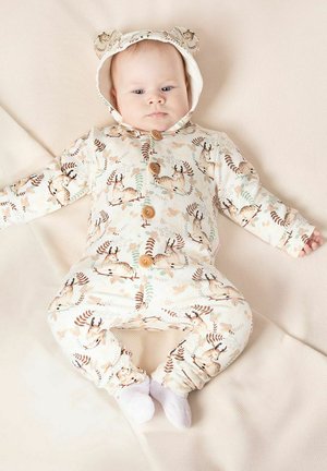 Kremowy kombinezon z kapturem z uszkami niedźwiedzia, drewnianymi guzikami oraz nadrukami nawiązującymi do przyrody, w tym sarną i liśćmi. Miękki, elastyczny materiał.