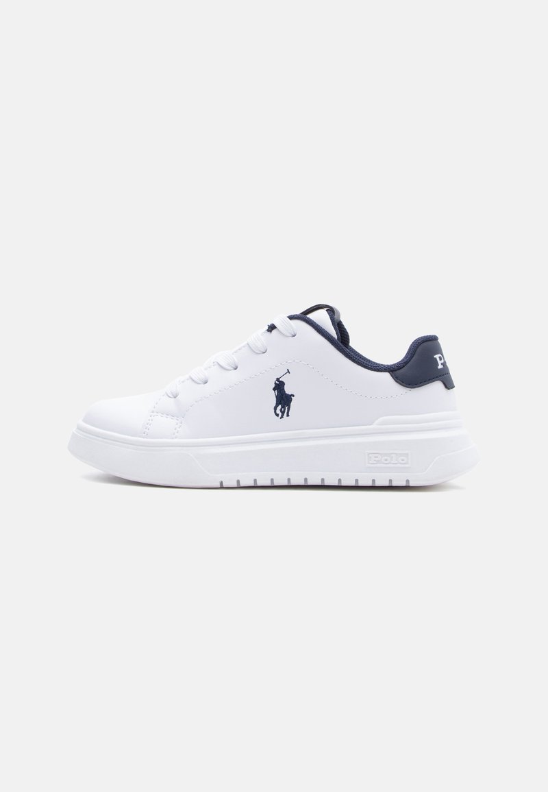 Fehér, alacsony szárú sportcipő sötétkék belső béléssel, fűzőkkel, valamint egy Polo logóval az oldalán és a sarkán. Vastag, fehér talp texturált alsó résszel.
