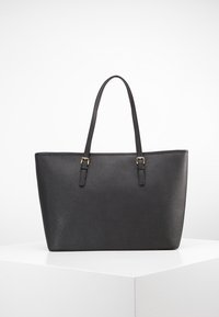 Sort tote bag med glat tekstur, rektangulær form og to håndtag. Udstyret med guldfarvet hardware og et minimalistisk design uden synlige mønstre.