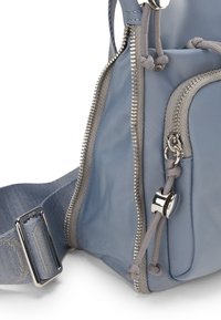 Borsa in nylon grigio chiaro con più cerniere, tracolla regolabile e finitura strutturata, con hardware e dettagli in argento.