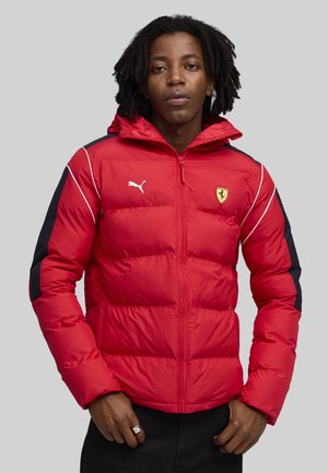 Rød polstret jakke med sorte detaljer og hvid piping, med hætte og Ferrari-logo på brystet. Tekstureret, isoleret design.