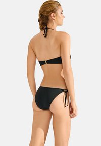 Zwart bikini set met een halternek-top en verstelbare strik-zijde broekjes. Glad materiaal met een subtiele glans, voorzien van gouden hardware accenten.