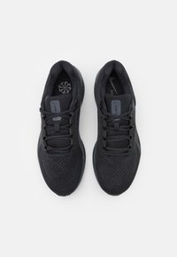Czarne buty sportowe z teksturowanego siatkowego wierzchu, wzmocnioną piętą i płaskimi sznurowadłami. Minimalistyczny design i logo na języku.
