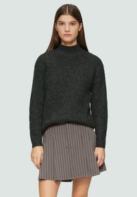 Ciemnoszary sweter z prążkowanej dzianiny z wysokim kołnierzem, zestawiony z szaro-prążkowaną spódnicą. Sweter ma długie rękawy i luźny krój.
