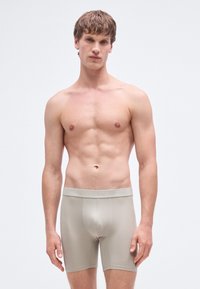 Béžové boxerky z mäkkého materiálu, s priliehavým strihom, elastickým pásom a hladkou textúrou. Vhodné na každodenné nosenie.
