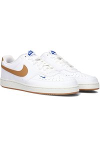 Zapatillas de cuero blancas con un swoosh marrón y acentos azules. El diseño perforado en la puntera, los cordones blancos y una suela de goma completan los detalles.