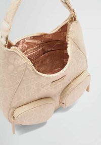 Borsa a spalla beige con motivo a logo in rilievo, hardware dorato, interni foderati e due tasche anteriori con zip.