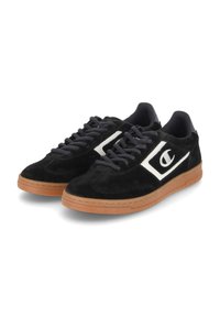 Adidași negri din suede cu accente albe, talpă din cauciuc, design cu șireturi și guler căptușit pentru confort. Prezintă un logo pe lateral.
