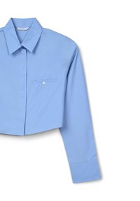Camicia a maniche lunghe tagliata in cotone azzurro chiaro con colletto a punta, chiusura frontale con bottoni e una tasca sul petto.