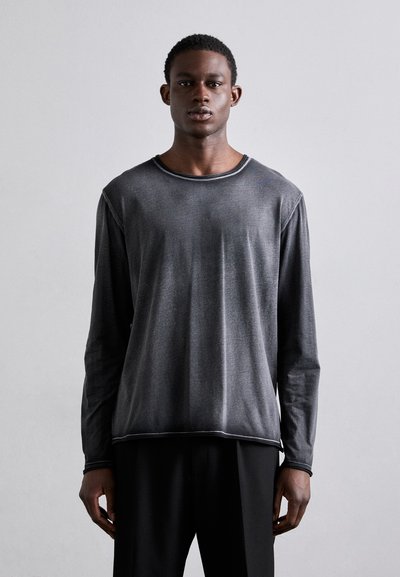 T-shirt à manches longues, col rond, en gris foncé, fabriqué en tissu lisse et léger. Présente des coutures contrastantes le long de l'encolure et de l'ourlet.