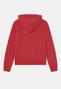 Sweatshirt rouge avec capuche, fabriqué en tissu doux. Il possède des manches longues, des poignets côtelés et un ourlet court. Pas de graphismes ni de motifs visibles.