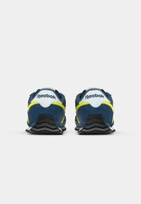 Mėlyni zomšiniai sportbačiai su geltonais akcentais ir juodais guminiais padais. Yra paminkštinta apykaklė ir liežuvėlis, su "Reebok" logotipu ant kulno.