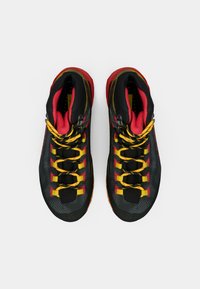 Czarno-czerwone buty typu high-top z żółtymi sznurówkami, z teksturowanym wierzchem, wyściełanym kołnierzem i gumową podeszwą z wielokolorowym akcentem.