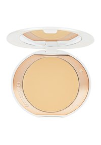 Compact powder in a round white case with a reflective gold rim and a smooth beige surface. Features brand engraving and a clear lid.