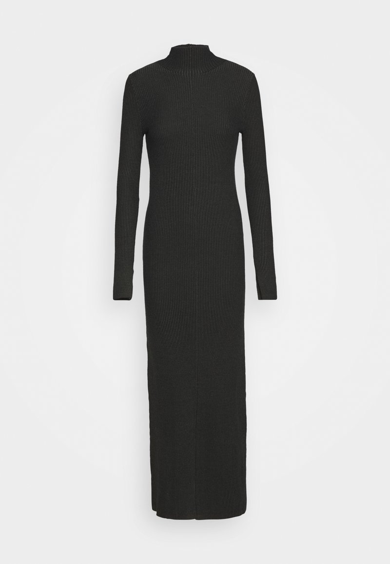 Longue robe noire en maille côtelée avec manches longues et col haut s'étendant jusqu'au milieu du mollet sur fond blanc.