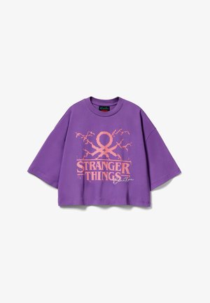 T-shirt viola corta in cotone con una audace grafica rosa "STRANGER THINGS" e ulteriori elementi di design. Vestibilità comoda e maniche corte.