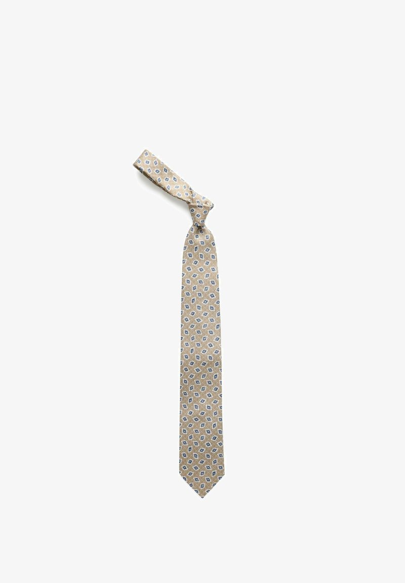 Cravate beige avec petit motif floral géométrique bleu et blanc, nouée en nœud lâche sur fond blanc.