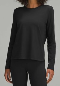 Czarny longsleeve wykonany z gładkiej bawełny. Posiada okrągły dekolt oraz luźny krój, zestawiony z czarnymi legginsami, tworzy monochromatyczny wygląd.