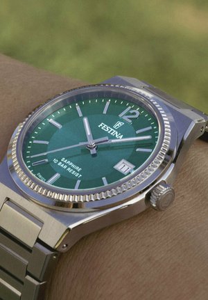 Orologio in acciaio inox argento con quadrante verde, indicatori delle ore argentati, display della data e una lunetta texturizzata. Impermeabile fino a 10 bar.