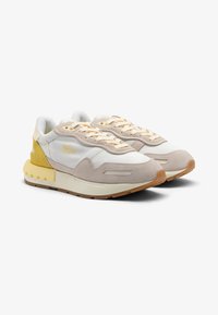 Witte en lichtbeige sneakers met gele accenten, van suede en mesh materiaal, ronde neus, gewatteerde rubberen zool en vetersluiting aan de voorkant.