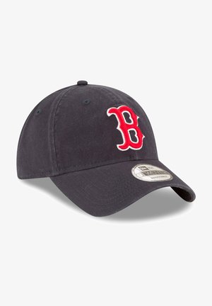 Navy baseball cap made of cotton with adjustable strap, featuring a red embroidered "B" logo on the front and a curved brim.