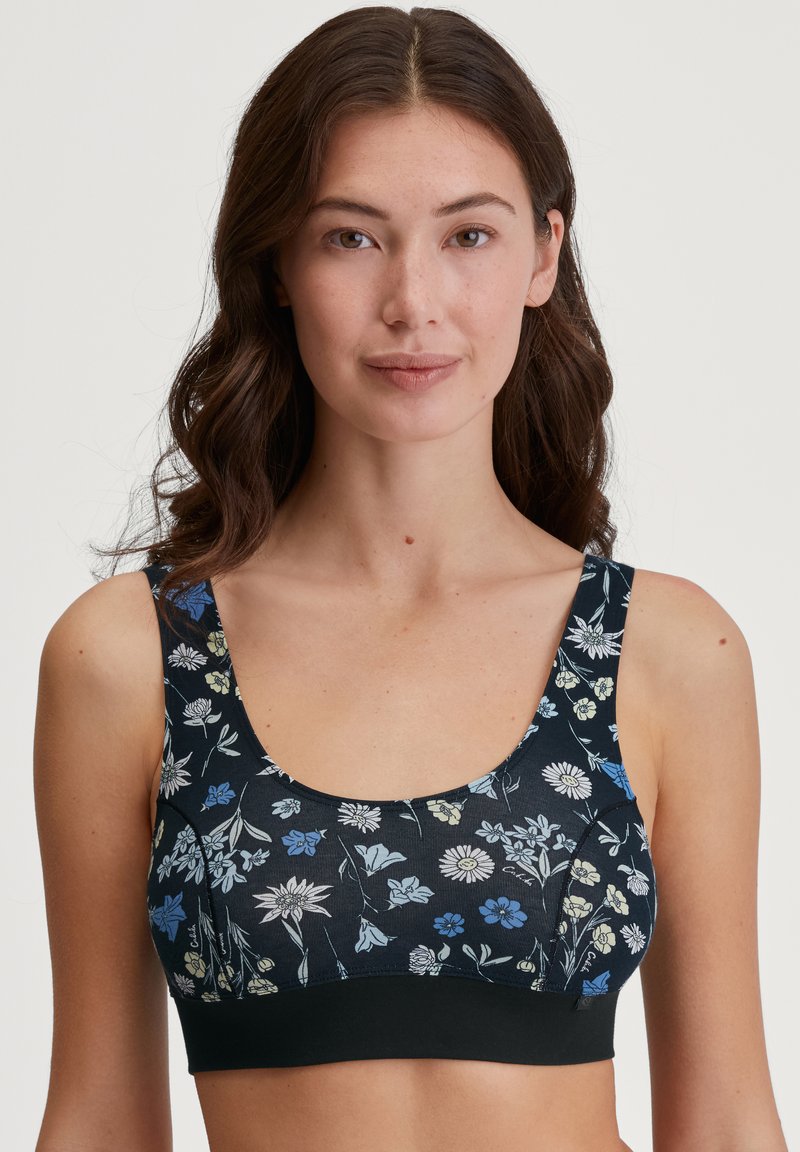 Zwarte bloemen bralette met blauwe, witte en gele bloemen. Zacht materiaal met een geribbelde textuur, brede banden en een elastische band aan de onderkant.