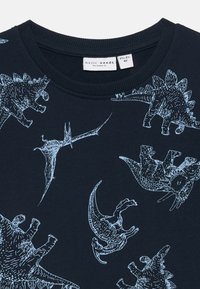 Granatowy sweter z jasnoniebieskimi grafikami dinozaurów, w tym wzorami stegozaura i ptaka dinozaura, z prążkowanym dekoltem i mankietami.