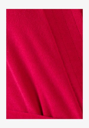 Tessuto a maglia fucsia con superficie testurizzata e motivi a coste verticali, che si drappeggia delicatamente e si sovrappone ai bordi.