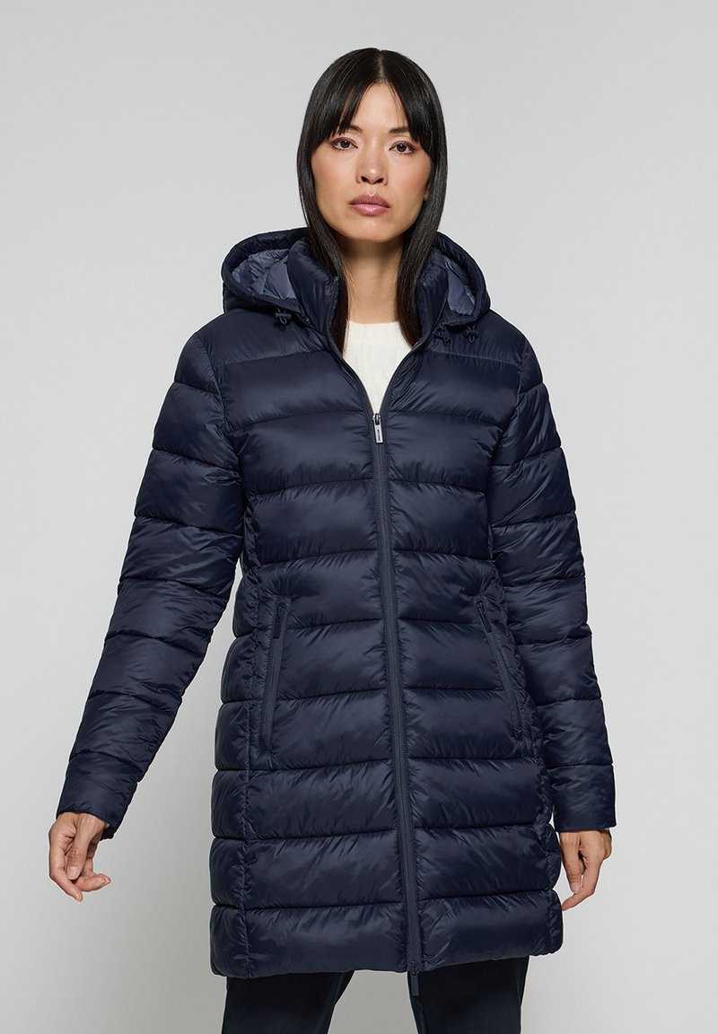 Marinblå puffjacka med huva, med dragkedja fram, horisontell sömnad och sidofickor. Slät, glänsande tyg med en något vadderad textur.