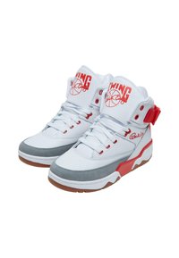 Adidași de baschet cu glezna înaltă, din piele albă și suede gri, cu accente și logo-uri roșii, având o talpă din cauciuc și un design cu șireturi.