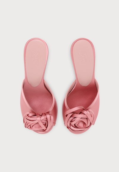 Paire de sandales roses en satin ouvertes à l’orteil, à enfiler, avec un détail décoratif en nœud en forme de rose sur chaque bride avant.