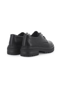 Zapatos de vestir de cuero negro con puntera redonda, suela de goma gruesa y diseño con cordones. Textura suave y detalles de costura minimalistas.