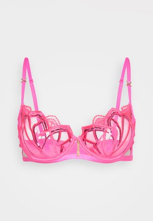 Pink lace bra with sheer mesh, intricate embroidered details, and decorative hardware accents on straps. Features a structured shape.