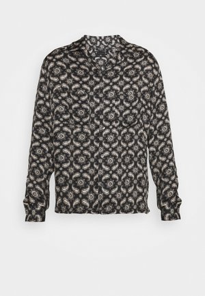Black long-sleeve shirt featuring a paisley pattern in cream and gray. Smooth fabric, collarless design, and button closure at front.