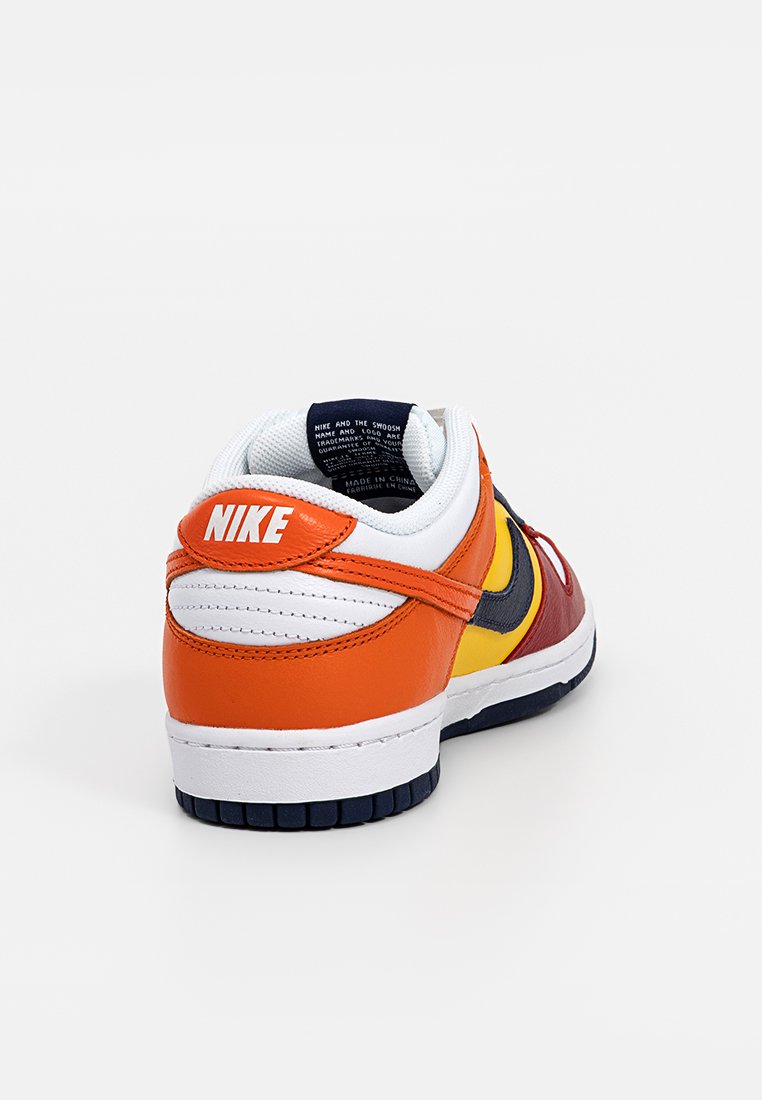 Nike Sportschuhe mit Obermaterial aus Leder und Synthetik, featuring orange, rot, gelb und marineblau Abschnitten, weiße Zwischensohle und strukturierte Gummisohle.